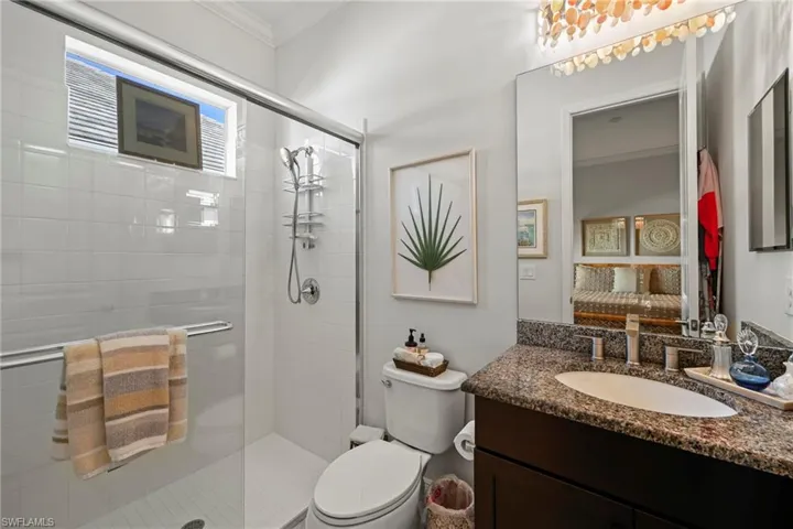 Full bathroom with ornamental molding, vanity, and a stall shower
