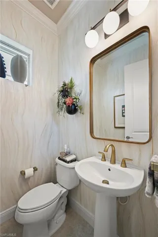 Pool Bathroom featuring ornamental molding and toilet