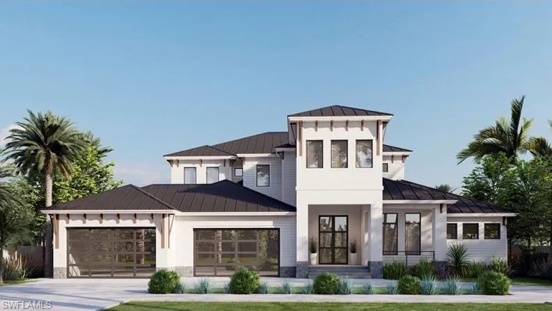 View of front facade featuring a standing seam roof, a metal roof, an attached garage, driveway, and stone siding
