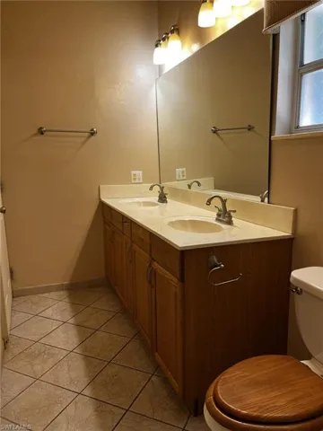 Bathroom featuring toilet and double sink vanity