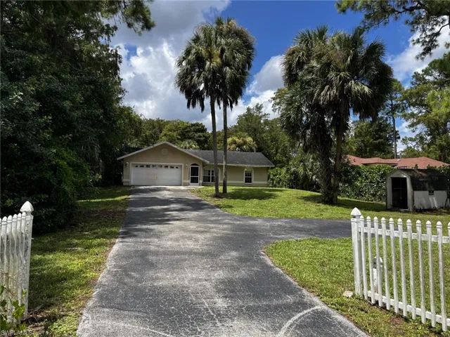 Ranch-style home with a front lawn, a garage, and a shed