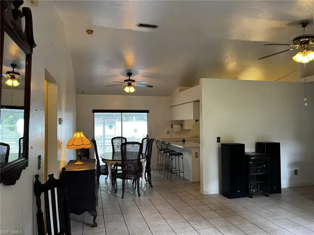 f'ront entry to tiled dining room with vaulted ceiling.