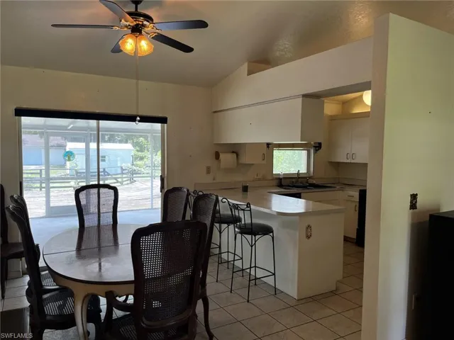 Tiled dining space featuring lofted ceiling and a wealth of natural light.
