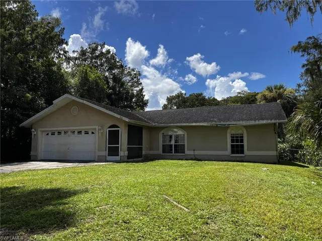 Ranch-style home with a front yard and a garage