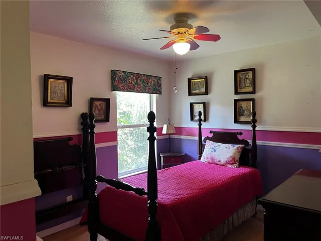 Guest Bedroom featuring a textured ceiling and dark hardwood / wood-style floors.