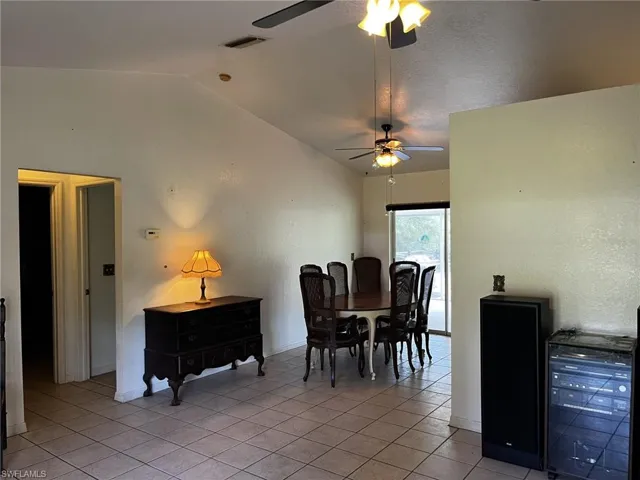 Dining space featuring lofted ceiling and light tile patterned flooring
