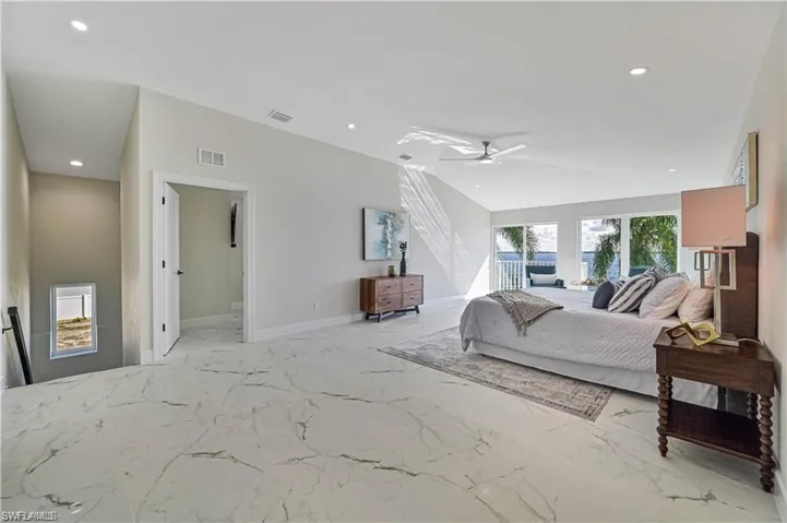 Bedroom featuring recessed lighting, vaulted ceiling, marble tiled floors, and a ceiling fan
