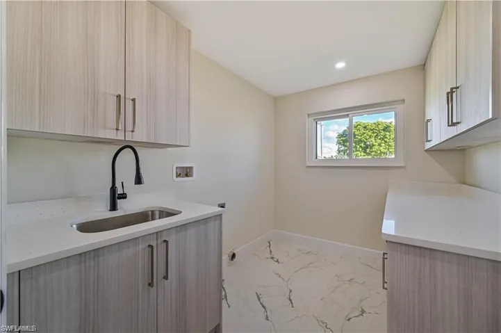 Washroom featuring washer hookup, light marble finish floors, cabinet space, hookup for an electric dryer, and recessed lighting