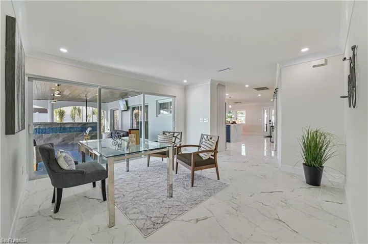 Dining area with recessed lighting, ornamental molding, and marble finish floors