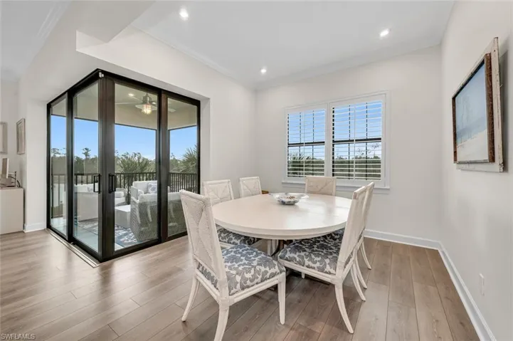 Dining room with a wealth of natural light, crown molding, baseboards, and wood finished floors