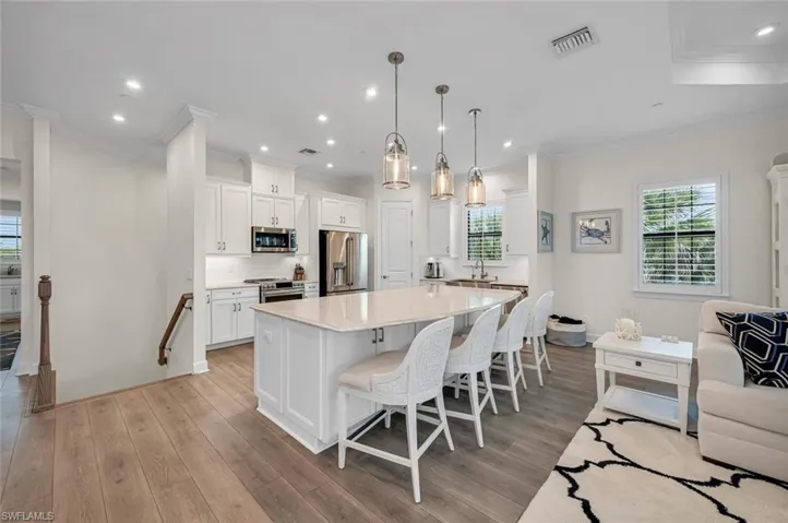 Kitchen with visible vents, a kitchen bar, light wood-style flooring, a large island, and stainless steel appliances