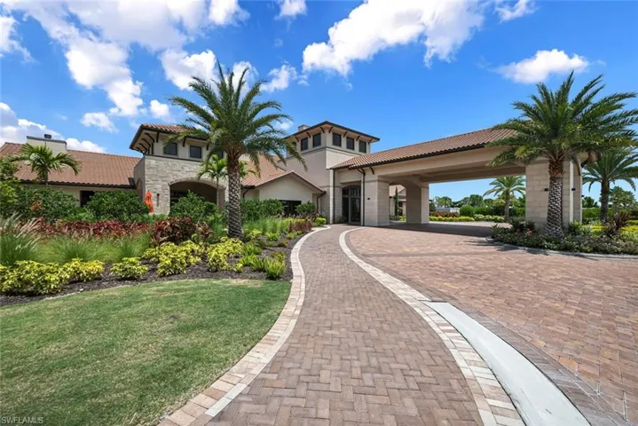 Mediterranean / spanish-style home featuring stone siding, a front yard, and a tiled roof