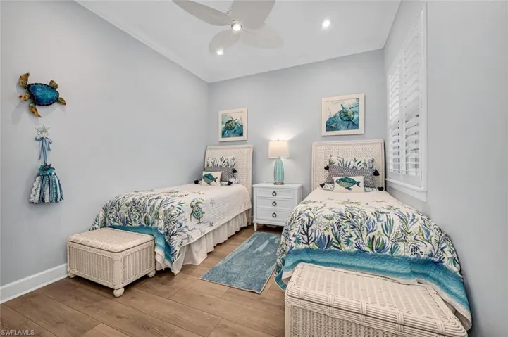 Bedroom featuring ornamental molding, a ceiling fan, baseboards, and wood finished floors