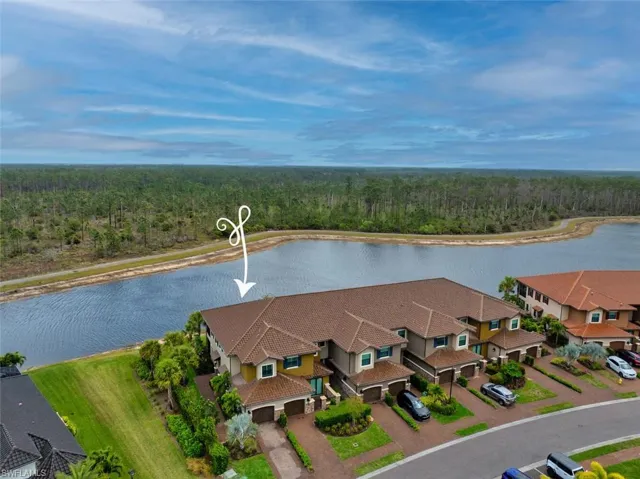 Aerial view featuring a residential view, a wooded view, and a water view