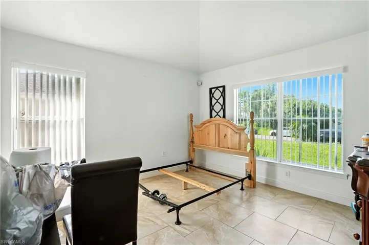 Bedroom with multiple windows and light tile patterned floors