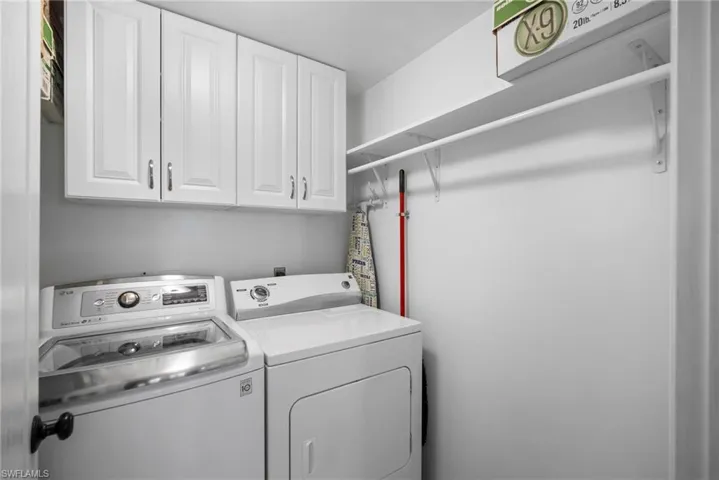 Washroom with separate washer and dryer and cabinets