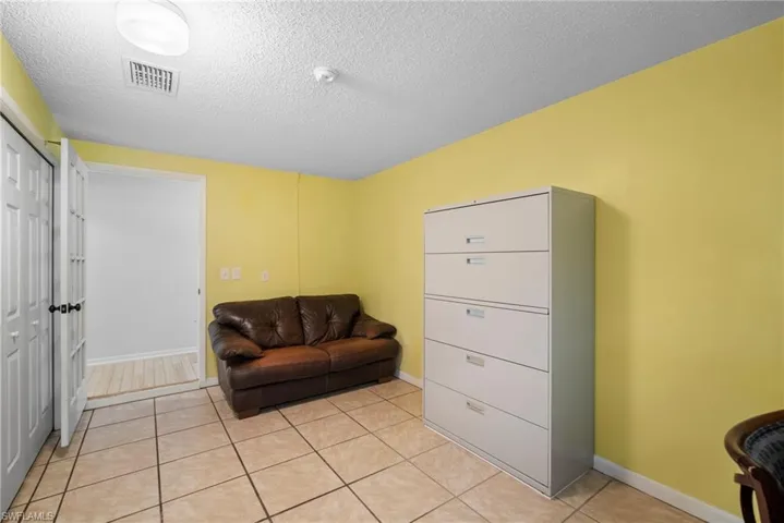 Living area with a textured ceiling and light tile floors