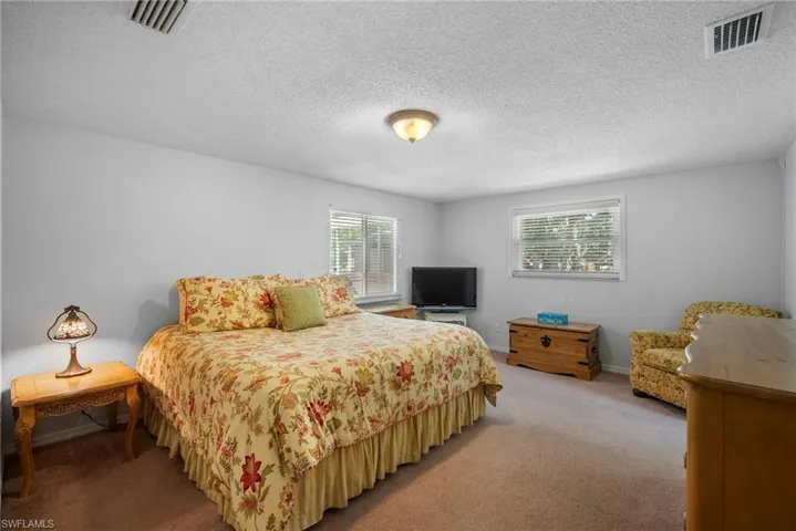 Bedroom with a textured ceiling and carpet floors