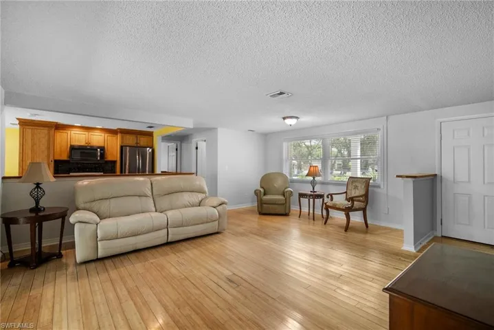 Living room with light hardwood / wood-style flooring and a textured ceiling