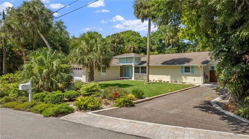 Single story home with a garage and a front yard