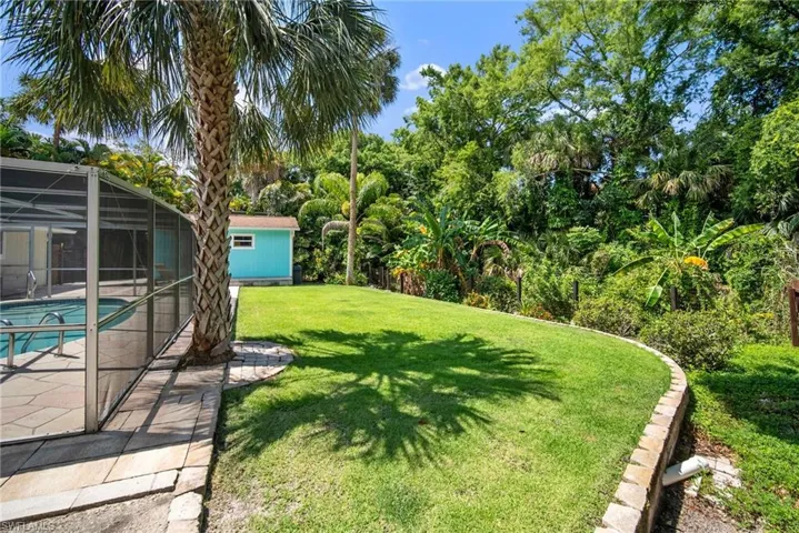 View of yard featuring glass enclosure and a patio area