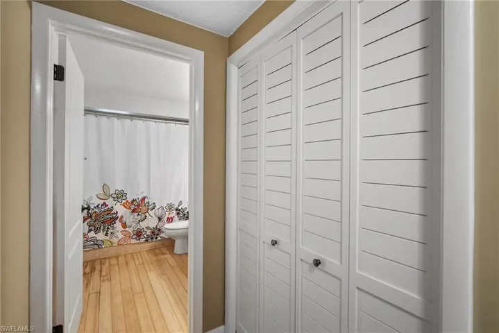 Hall featuring a textured ceiling and hardwood / wood-style floors
