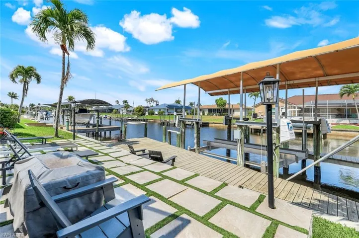 Dock with boat lift, a water view, and a residential view
