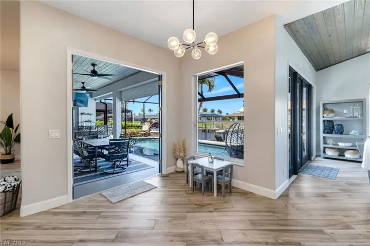 Dining area featuring wood finished floors, a chandelier, and baseboards