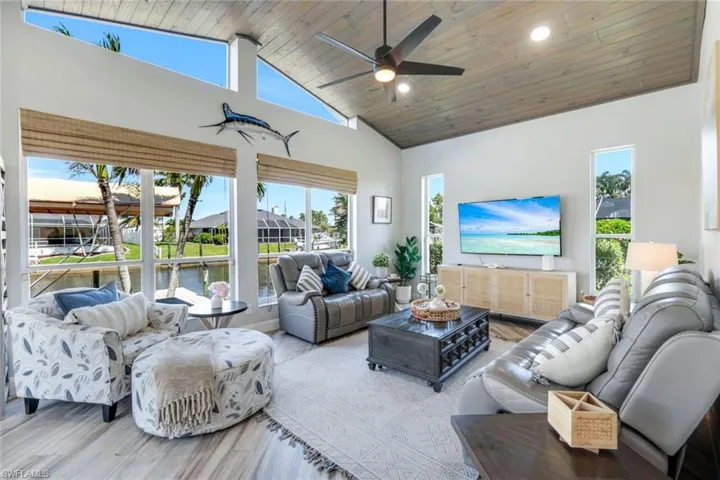 Living area with high vaulted ceiling, ceiling fan, wood ceiling, recessed lighting, and wood finished floors
