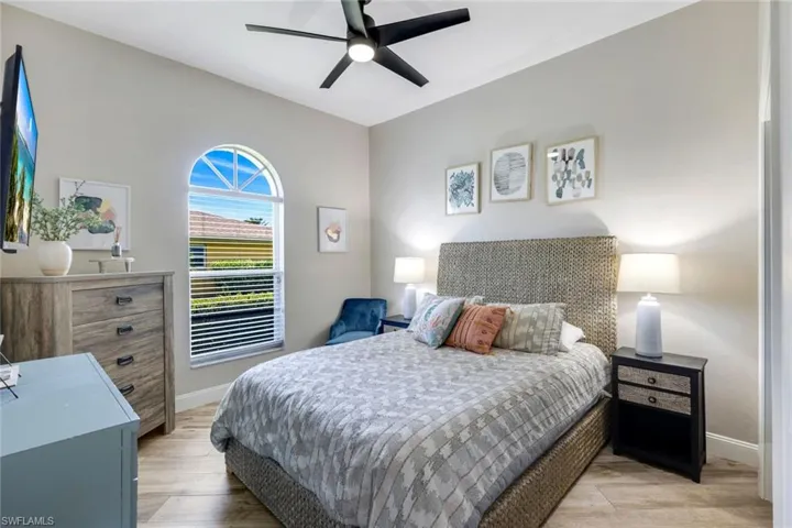 Bedroom featuring baseboards, light wood finished floors, and ceiling fan