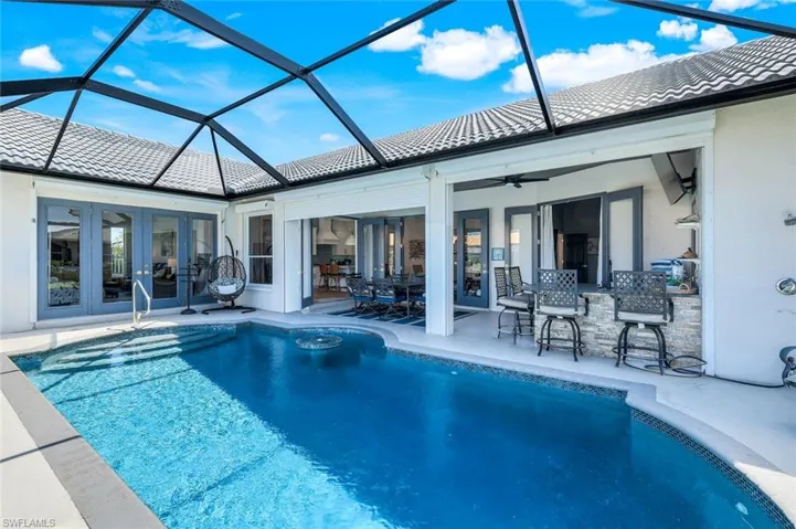 Swimming pool featuring french doors, a patio area, and glass enclosure