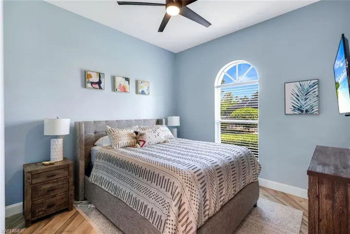 Bedroom featuring baseboards, wood finished floors, and a ceiling fan
