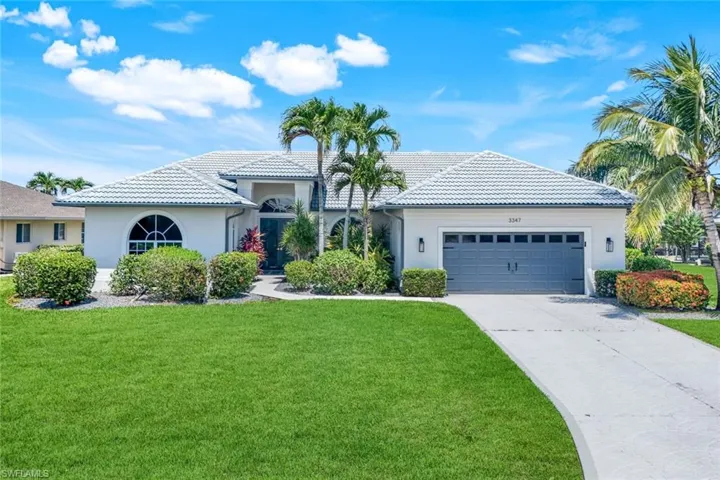 Mediterranean / spanish house with stucco siding, a garage, a front lawn, and a tiled roof