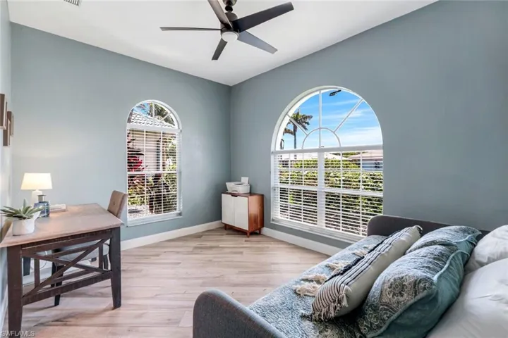 Office space with a ceiling fan, wood finished floors, and baseboards