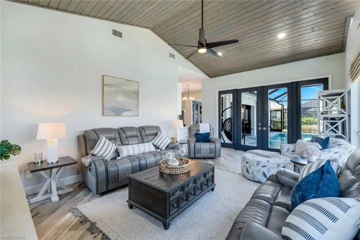 Living area with wooden ceiling, french doors, ceiling fan, a chandelier, and wood finished floors