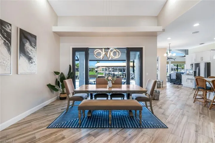 Dining area featuring a chandelier, light wood-type flooring, recessed lighting, and baseboards