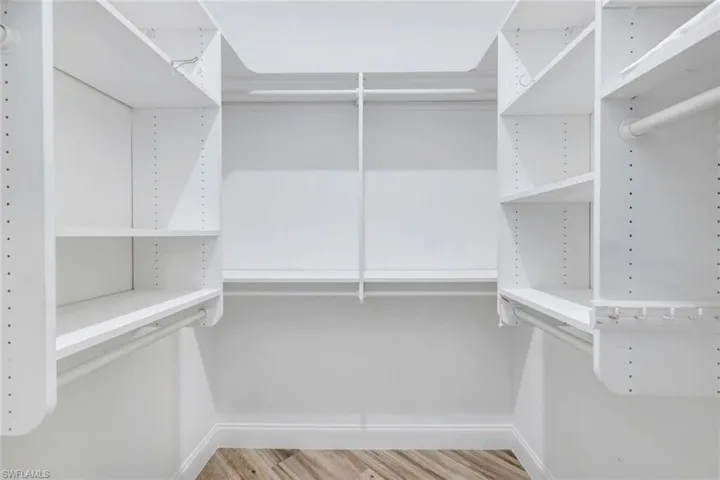 Walk in closet with wood finished floors