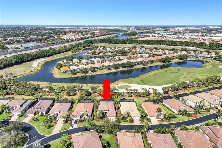 Aerial view of property and surrounding area with a golf club and nearby suburban area