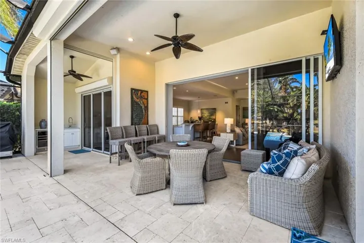 View of patio with an outdoor living / dining area, grilling area, and ceiling fan