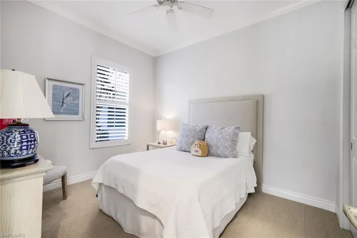 Bedroom featuring ornamental molding, carpet, and a ceiling fan