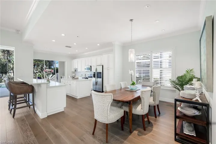 Dining space with crown molding, light wood finished floors, and recessed lighting