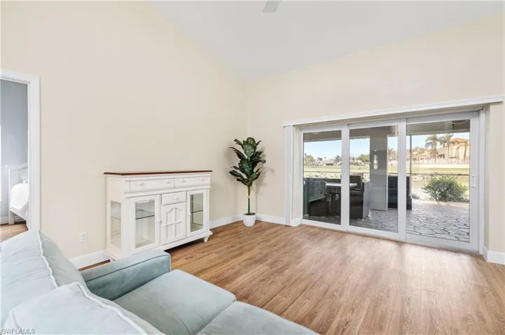 Living room featuring light wood-style floors, lofted ceiling, and ceiling fan