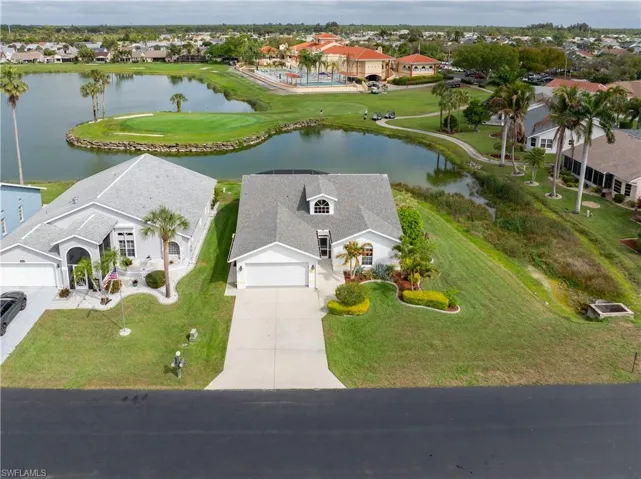 Aerial perspective of suburban area featuring a large body of water and a golf course