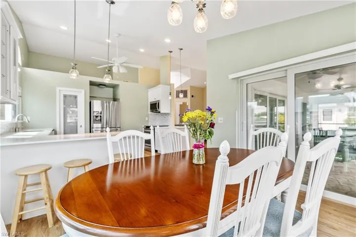 Dining space with ceiling fan, light wood-style flooring, and recessed lighting