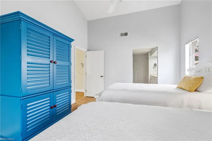 Bedroom featuring vaulted ceiling, a closet, light wood-style floors, a ceiling fan, and connected bathroom