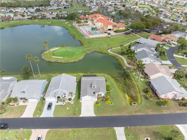 Aerial perspective of suburban area featuring a nearby body of water and a golf club