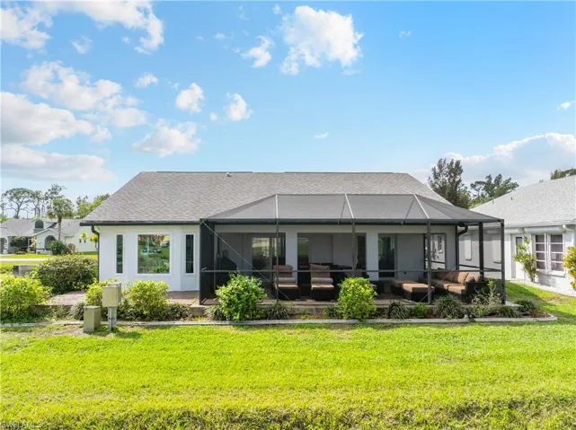Back of house featuring glass enclosure, an outdoor living space, a yard, and a sunroom