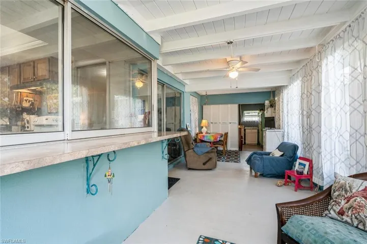 Sunroom featuring beam ceiling and ceiling fan