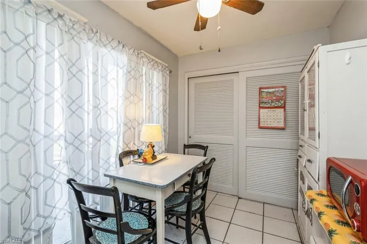 Dining room with light tile patterned floors and ceiling fan