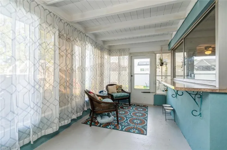 Sunroom / solarium with beam ceiling and ceiling fan